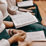 group of kids with bibles open on their laps